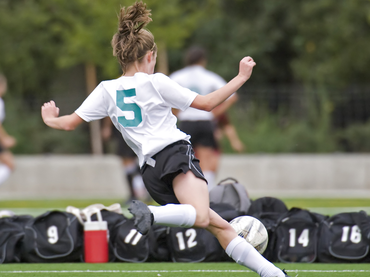 A teenage girl playing soccer